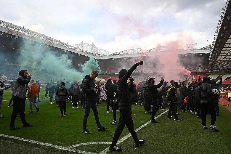 Fans protesting against Manchester United's owners on Sunday, with some storming the Old Trafford field before the Liverpool game. PHOTO: AGENCE FRANCE-PRESSE