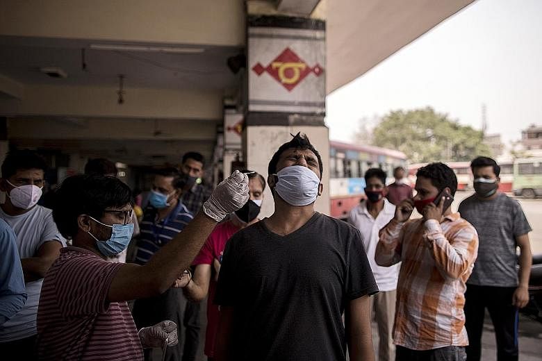 A health worker being tested for Covid-19 yesterday at an interstate bus station in Moradabad city in Uttar Pradesh. In India, delayed and false negative results have led to uncounted Covid-19 deaths and unchecked transmission of the virus, experts s