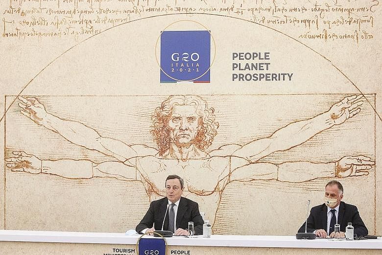 Italian Prime Minister Mario Draghi (far left) and Tourism Minister Massimo Garavaglia at a press conference in Rome on Tuesday, after the end of the G-20 ministerial meeting on tourism. Police officers checking the documents of travellers at Germany