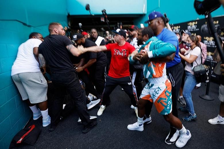 Floyd Mayweather and Jake Paul being separated after Paul grabbed Mayweather's hat. Insults were traded earlier, with Logan Paul taunting Mayweather over his 2011 domestic violence case.