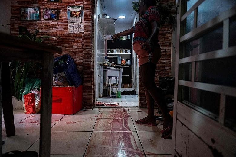 Above: Police officers in the Jacarezinho favela of Rio de Janeiro on Thursday during an operation against a gang of suspected drug traffickers. Below: A woman at the scene where an alleged drug trafficker was killed by police while trying to escape 