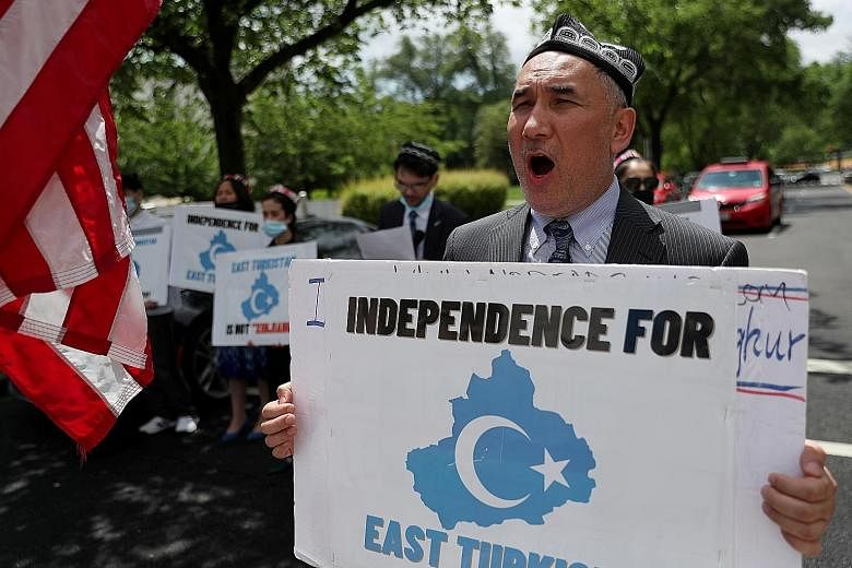 A 2019 photo of a facility believed to be a re-education camp in Xinjiang where mostly Muslim ethnic minorities are detained. PHOTO: AGENCE FRANCE-PRESSE Protesters in Washington last Wednesday urging the global community to act against China's treat