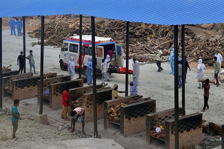 A body being carried to an open-air crematorium set up for coronavirus victims, inside a defunct granite quarry on the outskirts of Bangalore on Saturday. As India's Covid-19 crisis deepens, some of its large corporate houses have rolled out help. Co