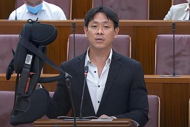 Mr Louis Ng (Nee Soon GRC) holding up a child's car seat in Parliament yesterday. He suggested providing one car seat for children aged nine months to four years, and another for those aged above four years. PHOTO: MCI