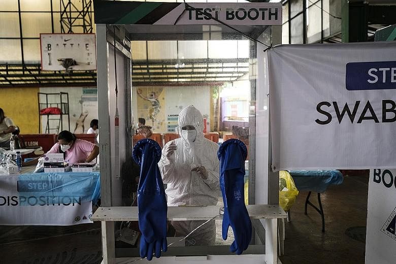 A health worker conducting a swab test at a Covid-19 test site set up in Quezon City, the Philippines, yesterday. The virulent "double mutant" strain was found in two Filipino seafarers who arrived in Manila from Oman and the United Arab Emirates in 