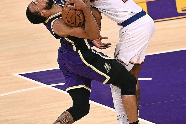 Los Angeles Lakers' Talen Horton-Tucker is fouled by Reggie Bullock of the New York Knicks during their 101-99 overtime win.