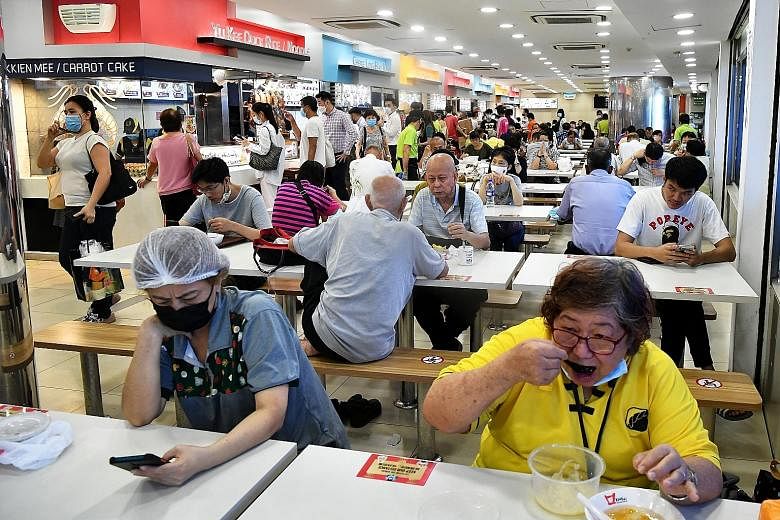 People buying food and eating at the Koufu foodcourt at Eastlink Mall, in Tampines, on Monday. Dining in at eateries, including hawker centres and foodcourts in indoor and outdoor areas, will not be allowed from tomorrow until June 13. All eateries w