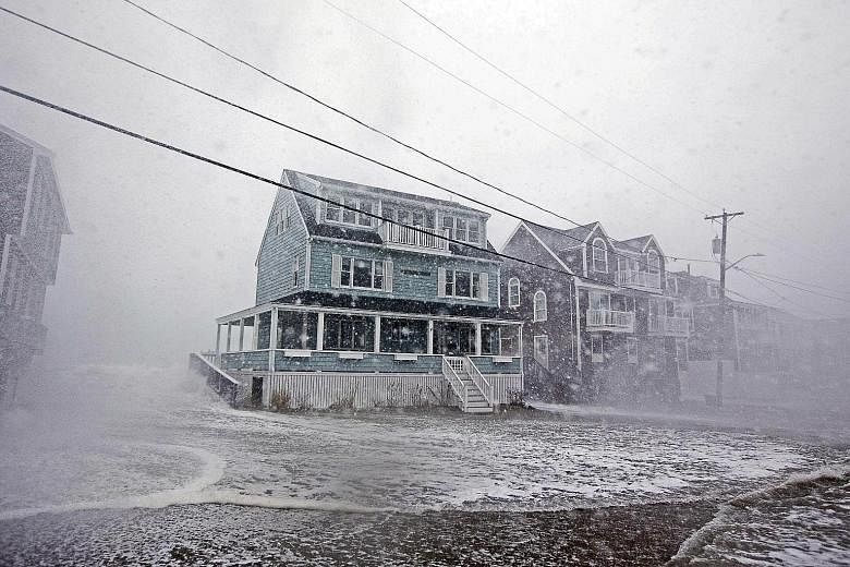 Waves crashing near some houses as a road started to flood during a large coastal storm in 2018 in Scituate, Massachusetts. The US Environmental Protection Agency's data shows the East and Gulf Coasts are flooding more often, while ice sheets are dis