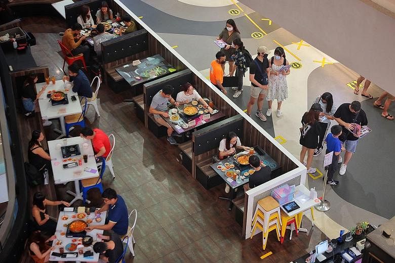 Diners at a restaurant at Bugis+ mall yesterday. For many restaurants, clearing the stocks of food in their kitchen was among the first things on their mind.