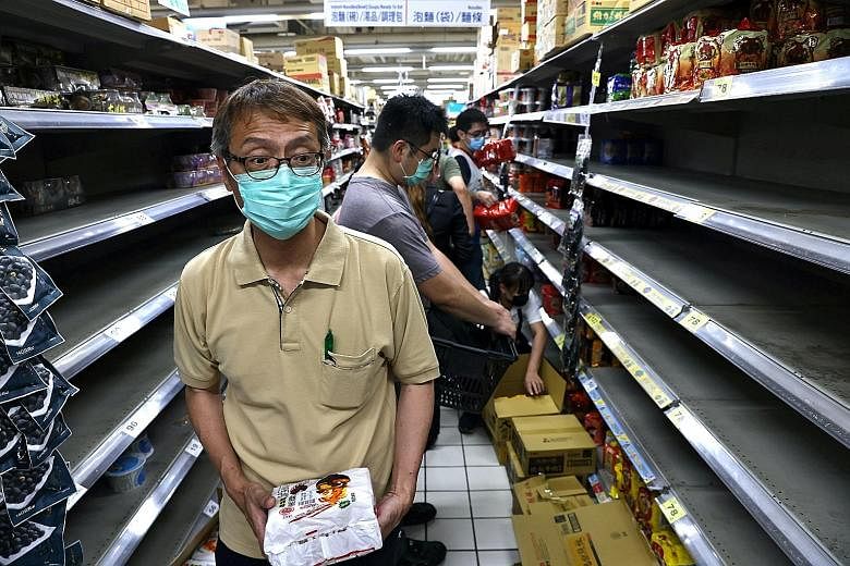 The announcement of a new alert level in Taipei and neighbouring New Taipei City yesterday prompted another wave of panic buying, as people flooded their local supermarkets and traditional markets to stock up on fresh and dried goods, as well as toil