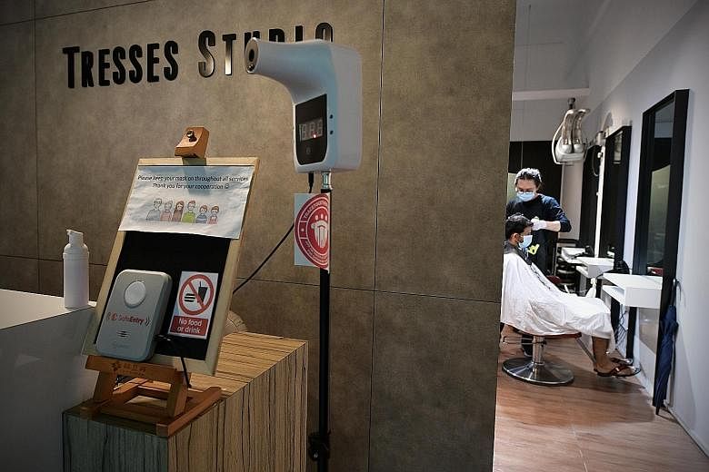 Hair salon Tresses Studio in Ghim Moh has installed a SafeEntry Gateway Box at its entrance that allows visitors to check in by holding their TraceTogether tokens or phones with the TraceTogether app near it. ST PHOTO: NG SOR LUAN