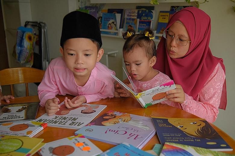 Ms Irene Chia and her sons Yiyang (far left) and Ruikai (left) reading Chinese books at home. Ms Far'ain Jaafar reading Malay books with her son Khalief Syafiq and daughter Nuhyah Syafiq to build the children's fluency in their mother tongue.