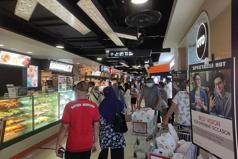 The basement level of Tampines Mall saw more people at around lunchtime yesterday, as patrons took away food, although the popular heartland malls that The Straits Times visited were significantly less crowded than usual. ST PHOTO: LUQMANUL HAKIM