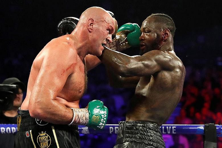 Tyson Fury (far left) exchanging blows with Deontay Wilder when the two boxers last fought in February last year in Las Vegas. Fury won via technical knockout to claim the WBC heavyweight title.