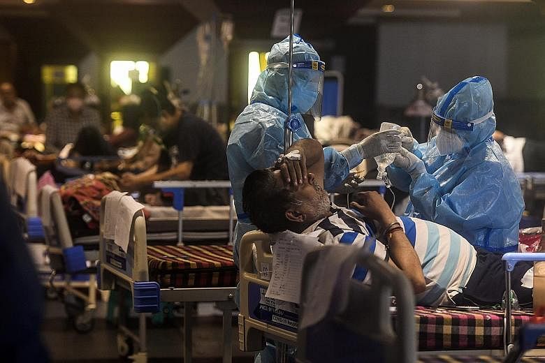 Healthcare workers at a makeshift facility in Delhi last month. India reported 267,334 new daily infections yesterday, taking its tally to 25.5 million - the world's second highest after the United States - with a death toll of 283,248, Health Minist