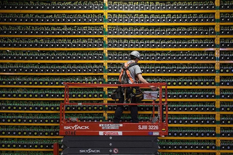 A 2018 file photograph showing a technician inspecting bitcoin mining equipment at a facility in Quebec, Canada. A Chinese State Council committee announced a crackdown on bitcoin mining and trading late last Friday, sending the digital currency tumb