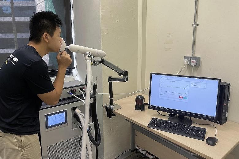 Mr Chan Tiong Ley, head of software and partnerships at Breathonix, demonstrating how the non-invasive breath test system is used. A person being tested for Covid-19 simply breathes out into a disposable mouthpiece connected to a breath sampler.