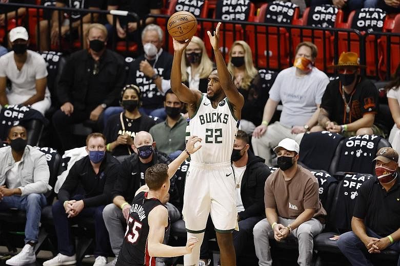 Milwaukee's Khris Middleton (shooting over Heat's Duncan Robinson) had a game-high 22 points as they beat Miami 113-84. PHOTO: AGENCE FRANCE-PRESSE