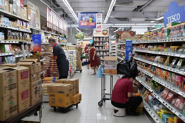 Staff at a FairPrice outlet in Hougang stocking shelves on May 15. Yesterday, Trade and Industry Minister Gan Kim Yong said Singapore is working with Malaysia to ensure the continued flow of essential supplies between the two countries as Malaysia im