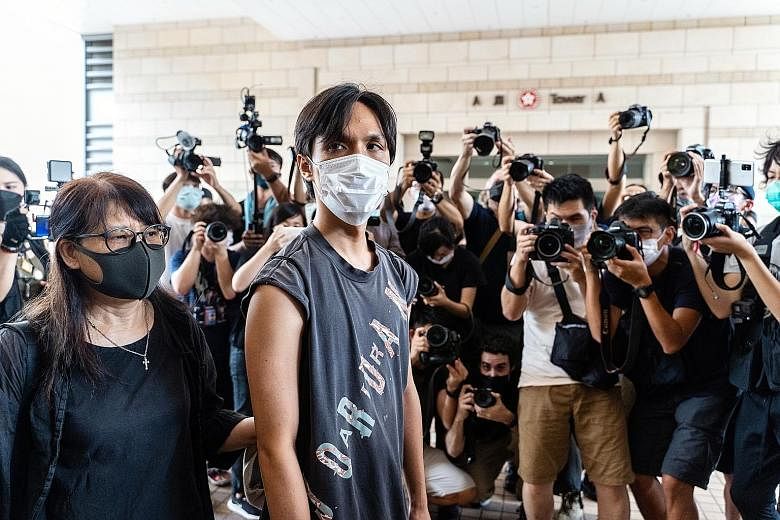 Pro-democracy activist Hendrick Lui Chi Hang (left) arriving at the West Kowloon Magistrates' Courts for a hearing yesterday. Pro-democracy activists are being prosecuted over their roles in organising a primary vote last year to select candidates fo