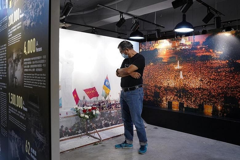 Mr Mak Hoi-wah, curator of the June 4th Museum in Hong Kong, looking at a bouquet during the reopening of the museum last Sunday after renovations. The museum is dedicated to telling the story of the June 4, 1989 Tiananmen Square crackdown on pro-dem