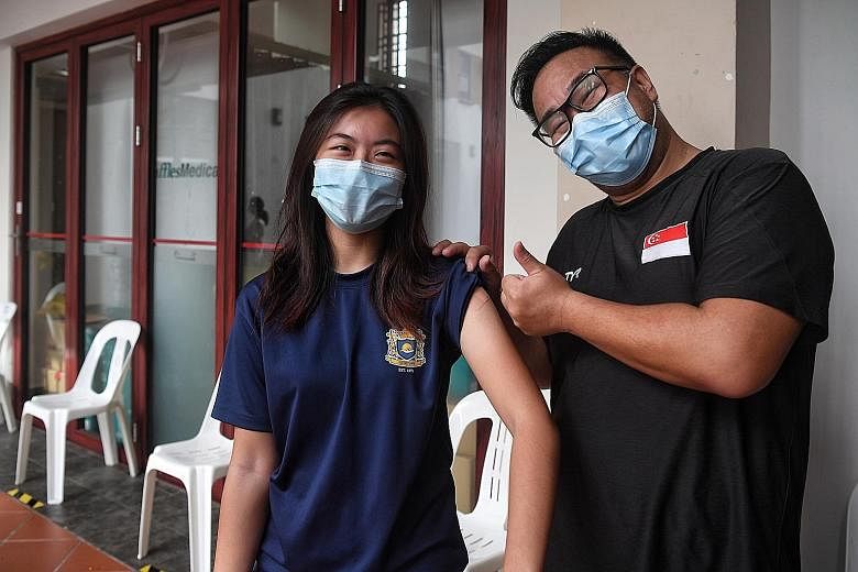 Trading strategist Samuel Wong, 51, with his daughter, Chloe, 18, who got her first dose at Tanjong Pagar CC yesterday. He says they wanted peace of mind as she is taking her A levels this year. Students waiting for their turn at the vaccination cent