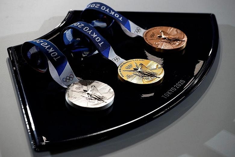 The medals and tray to be used for the medal ceremonies at Tokyo 2020 are seen at an event to mark 50 days to the opening ceremony. The tray is produced using recyclable thermoplastic polymer.