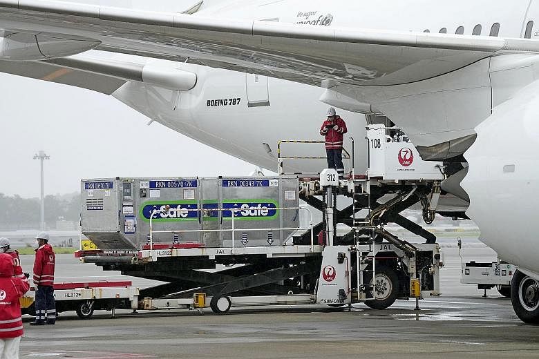 Workers at Japan's Narita Airport loading containers of vaccines on to a plane bound for Taiwan yesterday.