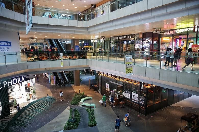 Even as Jem welcomed shoppers (above) back yesterday, the mall will continue to maintain its enhanced cleaning regime (left) and safe distancing protocols, said its operator Lendlease Singapore. Shoppers (above) at Westgate yesterday, the first day o