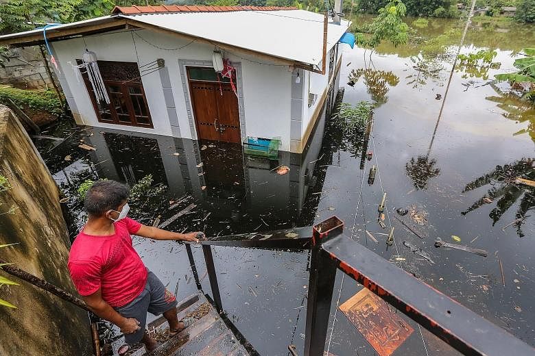 A Sri Lankan man next to his flooded house after heavy rainfall in the Kaduwela suburb of Colombo, Sri Lanka, on Saturday. Many parts of the island have been inundated due to heavy monsoon rains, and more than 245,000 people were affected.