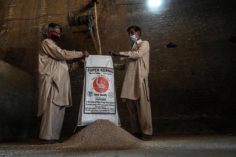 Workers at the Al-Barkat Rice Mills on the outskirts of Lahore, Pakistan. The country is opposing India's move to gain an exclusive trademark - protected geographical indication - for its basmati rice from the European Commission.