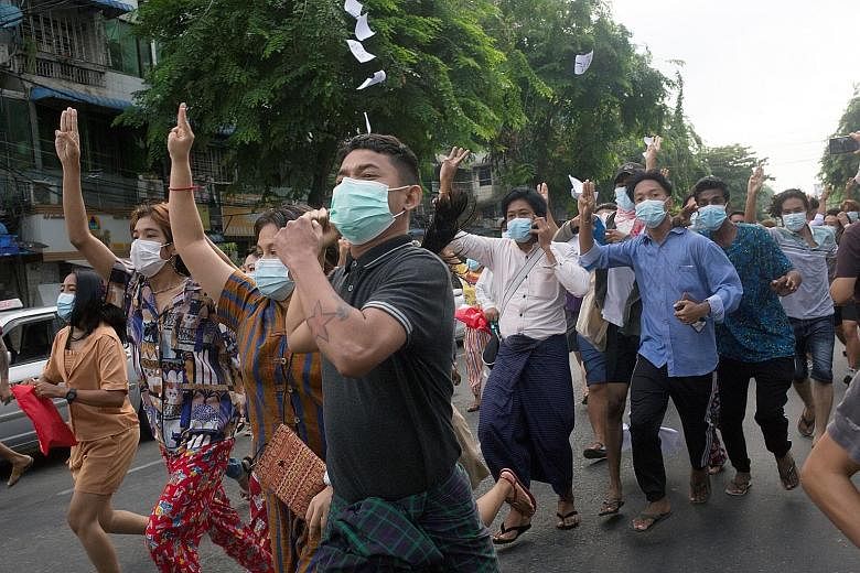 Anti-coup protesters showing the three-finger salute during a flash mob protest in Yangon last Thursday. Several Asean ministers at the special meeting expressed disappointment at the lack of progress in a "five-point consensus" towards a peace proce
