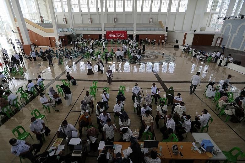 People waiting to be vaccinated at Banda Aceh, Indonesia, yesterday. The country seeks to inoculate more than 180 million, out of its 270 million population, by March next year to reach herd immunity. PHOTO: EPA-EFE