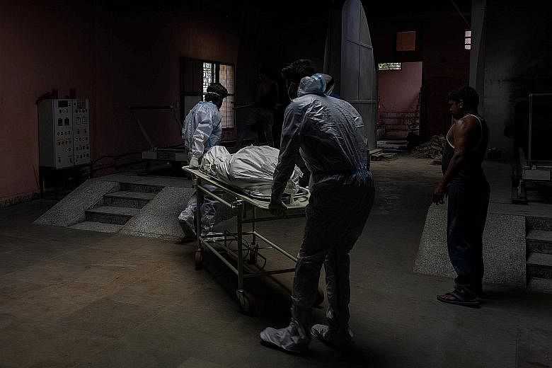 The body of a Covid-19 victim being moved to a crematorium in New Delhi yesterday. Concerns around under-reporting of deaths in India were heightened during the second wave in the past two months as crematoriums overflowed with bodies of Covid-19 vic