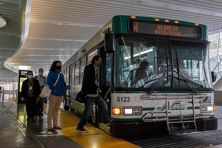 Commuters wearing masks boarding a bus in San Francisco, California, on Wednesday. The US Centres for Disease Control and Prevention said it will no longer require travellers to wear masks in outdoor transit hubs and in outdoor spaces on ferries, bus