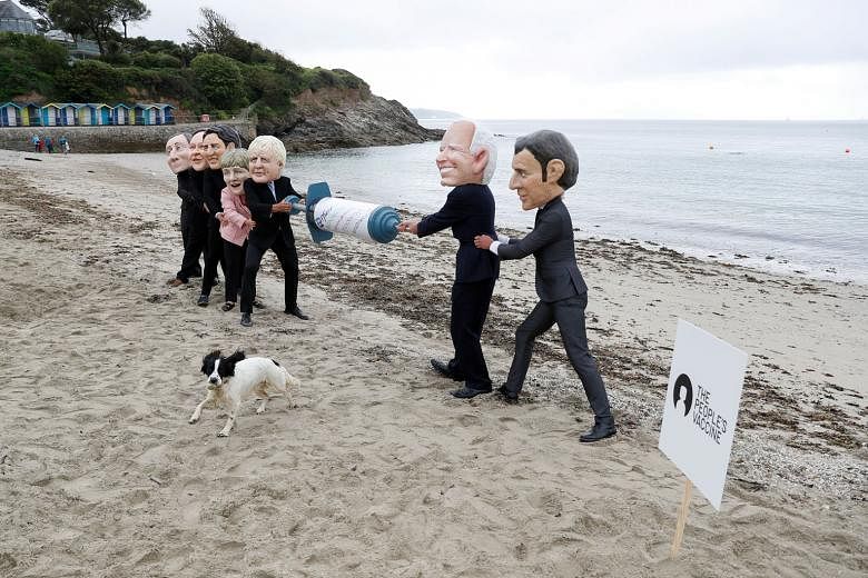Oxfam activists depicting G-7 leaders fighting over a Covid-19 vaccine yesterday, at a protest on a beach near Falmouth, on the sidelines of the G-7 summit, in Cornwall, England. The G-7 is now seen as representative of a bigger project: that of proj