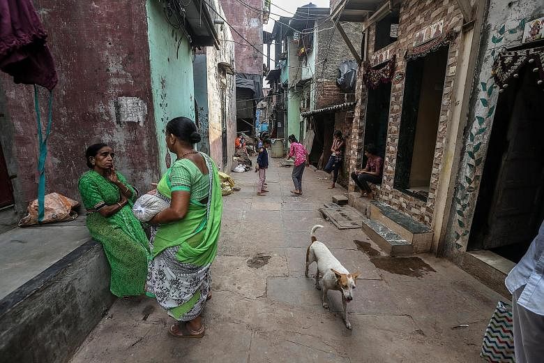 Residents gathering at a back lane inside the Dharavi slums in Mumbai on June 1. The densely populated Dharavi houses at least 850,000 people. "There are a lot of chawls and old buildings in Mumbai. Tenants staying in these chawls... can't afford to 