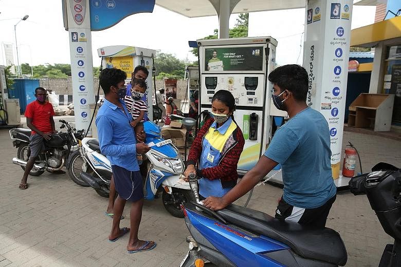 Motorcyclists queueing to refill fuel tanks at a petrol station in Bangalore. The Indian government estimates that the roll-out of 20 per cent ethanol blending in petrol can save about $5.3 billion a year in oil import costs.