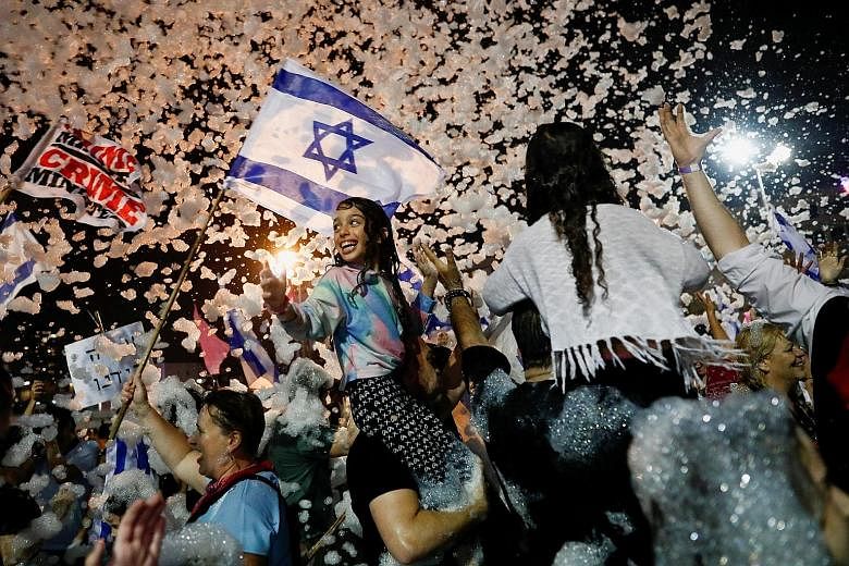 People celebrating after Israel's Parliament voted in a new coalition government, ending Mr Benjamin Netanyahu's 12-year tenure, in Tel Aviv on Sunday.