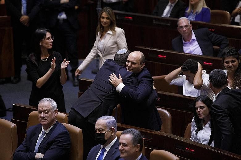 Mr Naftali Bennett, Israeli's new Prime Minister, embracing an attendee in Parliament in Jerusalem on Sunday, when Mr Benjamin Netanyahu's 12-year run in power came to an end. The new governing coalition has pledged to put aside conflicting political