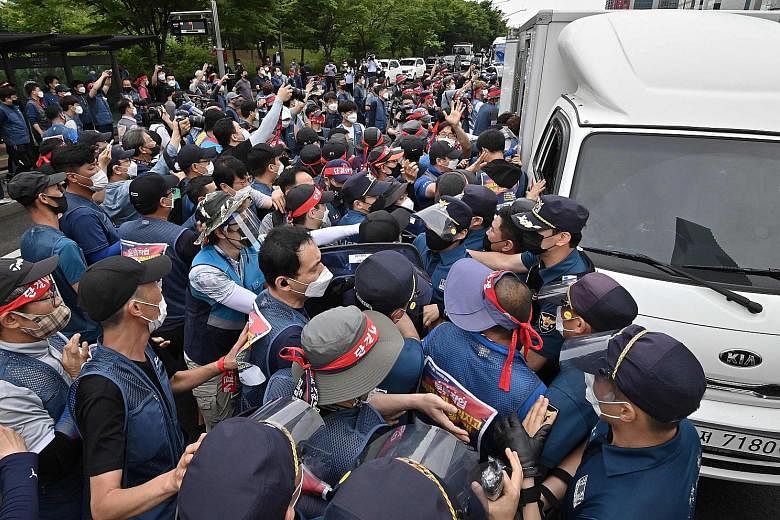 South Korean delivery workers scuffling with police officers in Seoul yesterday during a rally for better work conditions. Members of the Parcel Delivery Workers' Solidarity Union have been on strike since last week to demand that employers abide by 