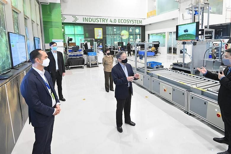 Minister for Trade and Industry Gan Kim Yong (centre) visiting the new facility set up jointly by A*Star and local manufacturing software company Arcstone yesterday. Sharing the lab details is Mr Willson Deng, chief executive of Arcstone. At the lab'