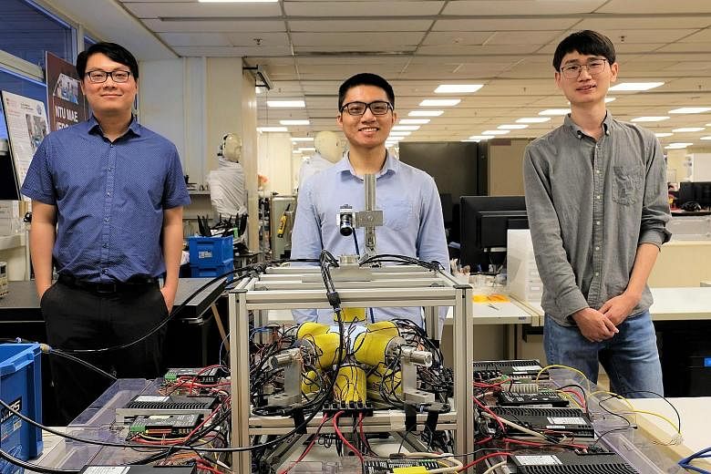 The Nanyang Technological University research team's members (from left) Assistant Professor Lum Guo Zhan and PhD students Yang Zilin and Xu Changyu with the electromagnetic coil system that generates the varying magnetic fields used to control the m