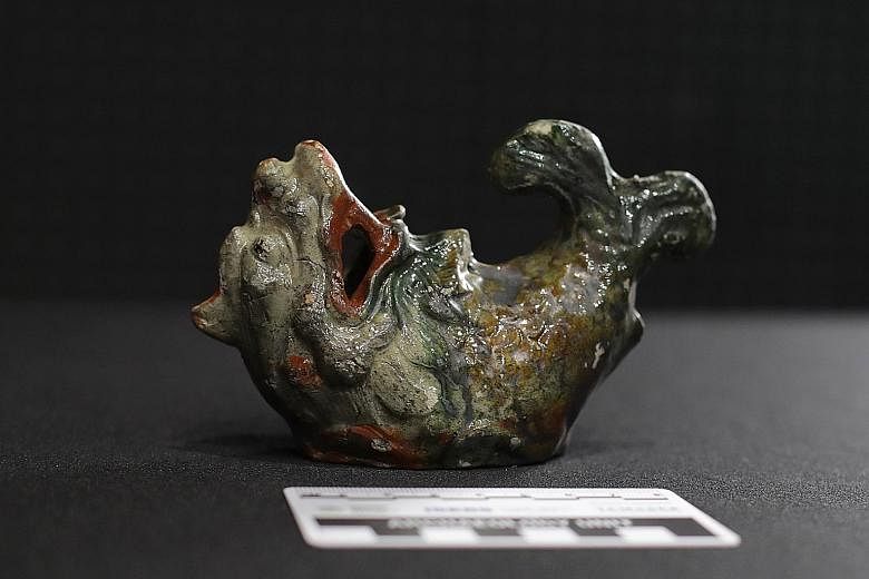 Some of the artefacts on the two shipwrecks found in Singapore waters include a small Longquan bowl (left), a blue and white porcelain chafing dish or food warming plate (centre), and a fully intact Makara figurine (right), which bears a remarkable l