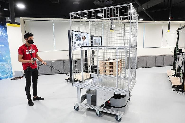 Third-year Temasek Polytechnic engineering student Muhammad Adeel shows how a trolley that can tow a load works. The idea is to build and design a trolley to tow, instead of lift, the load, for a project to improve the lifting ability of an automated