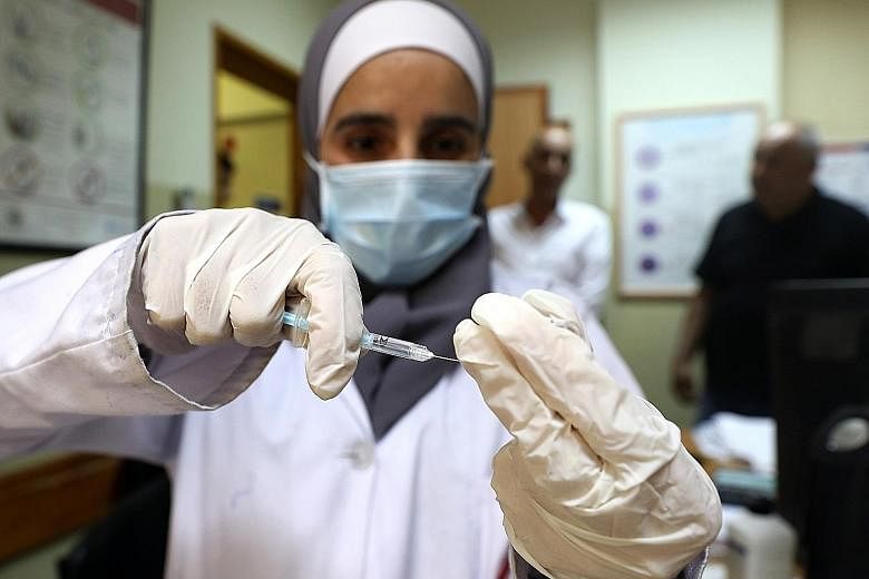 A Palestinian medical worker preparing a dose of the Pfizer-BioNTech vaccine at a healthcare centre in the West Bank city of Dura this month.