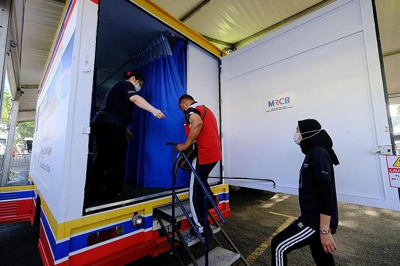A man entering a mobile Covid-19 vaccination clinic in Selayang, Malaysia, yesterday. As at Sunday, 1.6 million people, or 5 per cent of Malaysia's population, had received both doses of a vaccine. PHOTO: BLOOMBERG