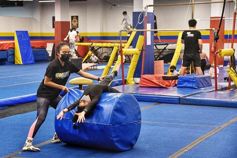 Children doing gymnastics at Gymkraft at Kallang Wave Mall yesterday, as indoor sports and physical activities for those aged 18 and below were allowed to resume shortly before the end of the school holidays. ST PHOTO: DESMOND WEE