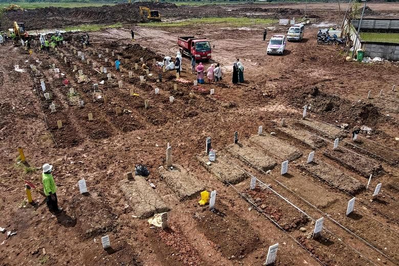 A funeral at a cemetery for Covid-19 victims in Jakarta yesterday. Official figures show Indonesia recorded 14,536 new infections yesterday, taking the number of overall cases past the two-million mark, and with nearly 55,000 deaths among a populatio