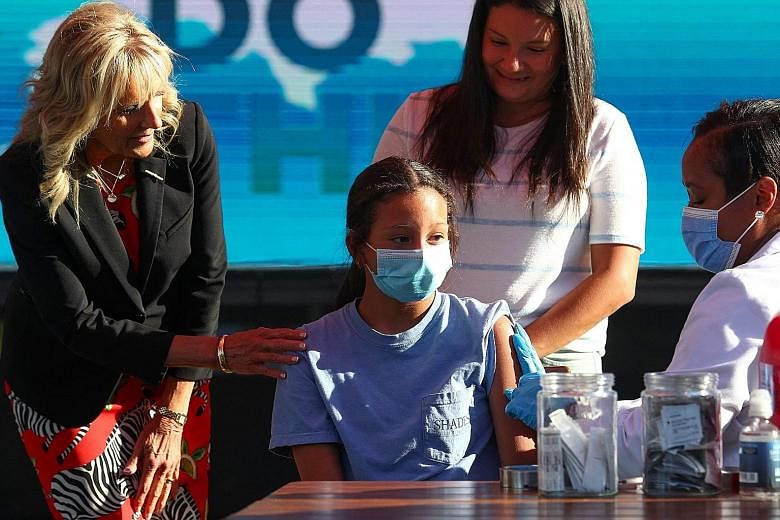 US First Lady Jill Biden with a 12-year-old receiving her vaccine jab in Tennessee on Tuesday. The White House has organised Instagram Live sessions and a YouTube townhall with influencers urging people to get jabs.